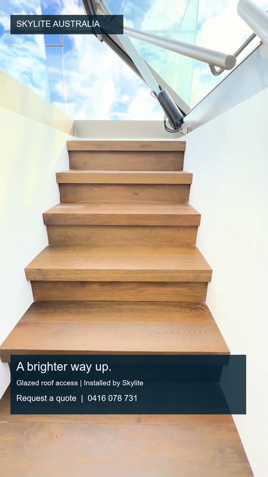 Timber stair beneath a glazed roof-access opening